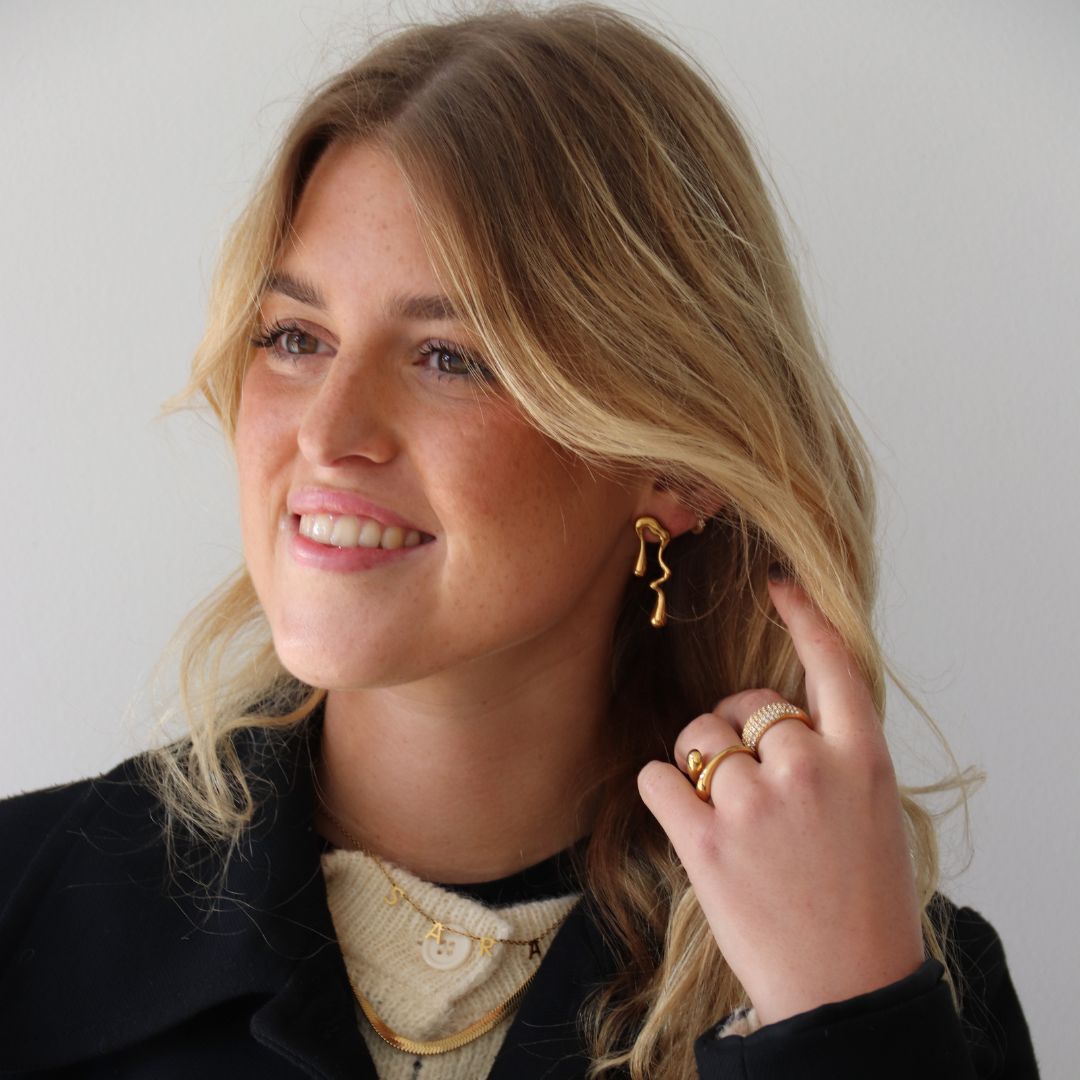 kvinde med haenge oereringe i guld